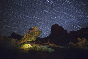 Majestic view of star trails over land against sky at night - CAVF54641