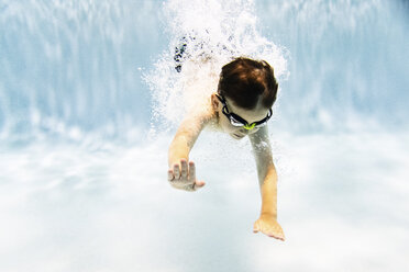 Hemdloser Junge mit Schwimmbrille beim Schwimmen im Pool - CAVF54661