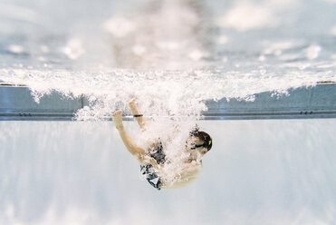 Hemdloser Junge schwimmt in voller Länge unter Wasser im Pool - CAVF54662