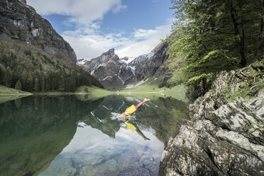 Hoher Blickwinkel von shirtless Mann taucht in See gegen Berge - CAVF54726