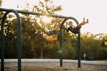 Spielende Brüder in voller Länge beim Schaukeln auf dem Spielplatz - CAVF54780