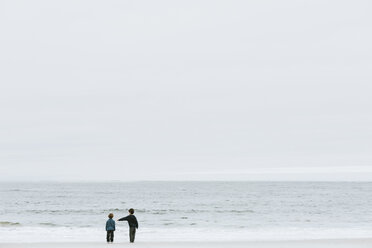 Rückansicht von am Strand stehenden Brüdern gegen den Himmel - CAVF54832