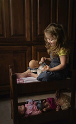 Full length of girl playing with doll at home - CAVF54872