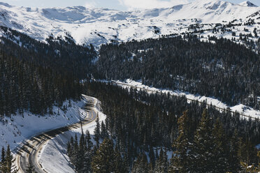 Hohe Winkelansicht der Straße inmitten von Bäumen auf einem Berg im Winter - CAVF54890