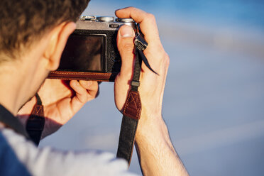 Nahaufnahme eines jungen Mannes, der mit einer altmodischen Kamera fotografiert - VPIF01052