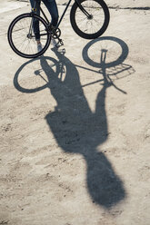 Close-up of man with commuter fixie bike on concrete slab - VPIF01068