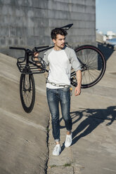 Junger Mann mit Fixie-Fahrrad an Betonwand - VPIF01076