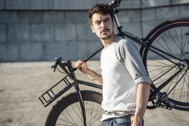 Junger Mann mit Fixie-Fahrrad an Betonwand - VPIF01077