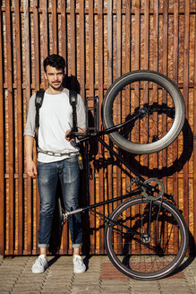 Porträt eines jungen Mannes mit Rucksack und Fixie-Fahrrad für Pendler - VPIF01080