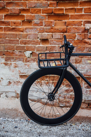 Frachtkäfig eines maßgeschneiderten Fixie-Fahrrads an einer Backsteinmauer, lizenzfreies Stockfoto