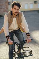 Portrait of young man riding commuter fixie bike in the city - VPIF01094