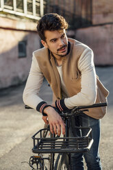 Young man with commuter fixie bike on a backyard in the city - VPIF01097