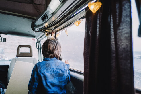 Moody picture of boy playing inside vintage camper van, Tenerife, Canary Islands, Spain - AURF07788