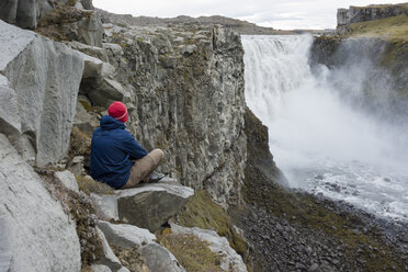 Junger Mann mit Blick auf den Detifoss-Wasserfall in Island. - AURF07850