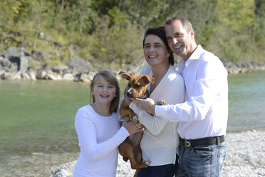 Glückliche Familie mit einem Hund an der Isar, Oberbayern, Deutschland - LBF02220