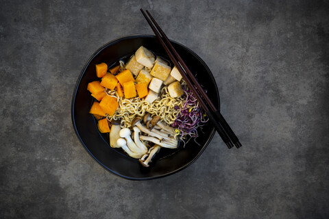 Miso-Ramen-Suppe mit Nudeln, Hokaido-Kürbis, roten Rettichsprossen, gebratenem Tofu, Shimeji-Pilz und Königstrompetenpilz, lizenzfreies Stockfoto