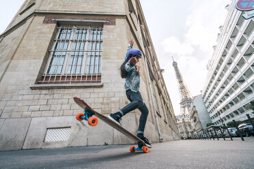 Niedriger Blickwinkel der Frau Skateboarding gegen Eiffelturm - CAVF54975