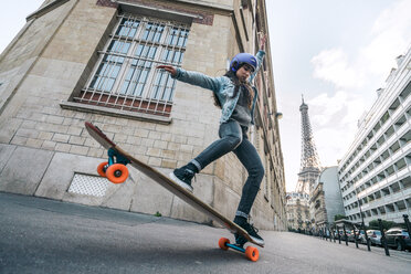 Frau in voller Länge auf dem Skateboard gegen den Eiffelturm - CAVF54976