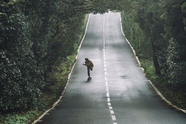 Man skateboarding on road amidst forest at Garajonay National Park - CAVF54987