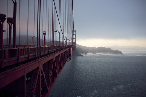 Golden Gate Bridge über der Bucht von San Francisco gegen bewölkten Himmel bei Sonnenuntergang - CAVF55001