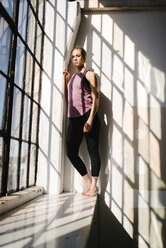 Portrait of athlete standing by window in gym - CAVF55032