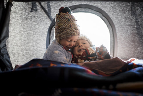 Lächelnde Geschwister sitzen im Dachzelt - CAVF55061