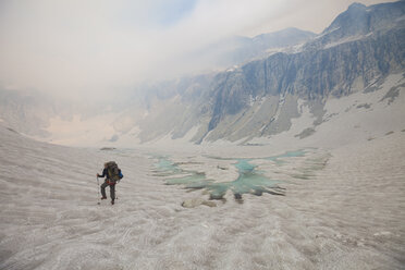 Rückansicht eines Wanderers auf einem Gletscher gegen den Himmel - CAVF55137