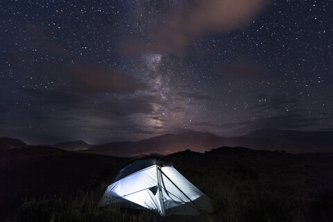 Illuminated tent on field against sky at night stock photo