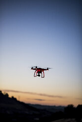 Low angle view of drone flying against sky during sunset - CAVF55344