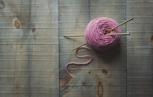 High angle view of woolen ball with knitting needles on table - CAVF55360