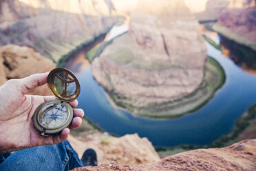 Tiefschnitt eines Mannes, der einen Navigationskompass gegen Horseshoe Bend hält - CAVF55367