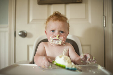 Close-up portrait of baby boy sitting on high chair at home during birthday - CAVF55453