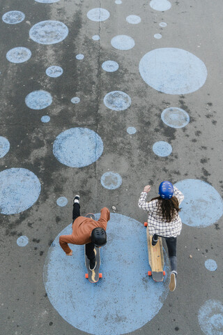 High angle view of friends skateboarding on footpath stock photo