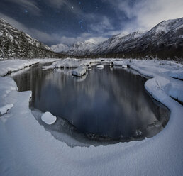 Malerischer Blick auf den See und die schneebedeckten Berge im Chugach State Park bei Nacht - CAVF55510