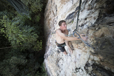 High angle view of shirtless hiker rock climbing - CAVF55543