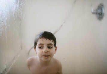 Hemdloser Junge drückt seine Nase an ein beschlagenes Fenster im Badezimmer - CAVF55547