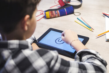 Close-up of boy drawing on tablet computer at table - CAVF55607