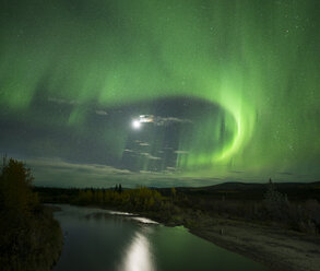 Scenic view river amidst field during aurora borealis at night - CAVF55661