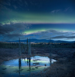 Scenic view of lake with reflection during aurora borealis against sky at night - CAVF55663