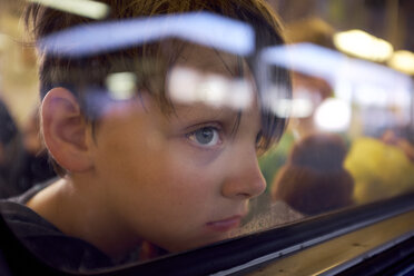 Junge, der durch das Fenster schaut, während er im Zug durch Glas gesehen wird - CAVF55666