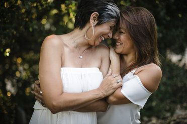 Cheerful mother and daughter standing at park - CAVF55682