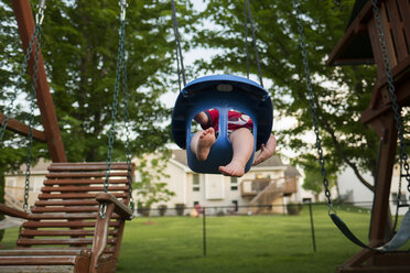 Niedriger Ausschnitt eines kleinen Jungen, der auf einem Spielplatz schaukelt - CAVF55695