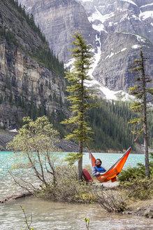 Mann entspannt sich in Hängematte am Peyto-See im Icefields Parkway - CAVF55788