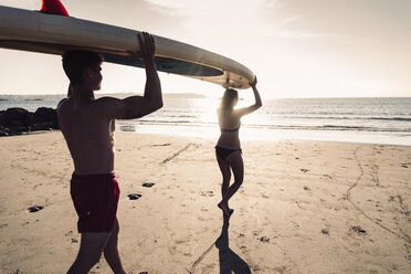 Frankreich, Bretagne, junges Paar mit einem SUP-Board am Strand - UUF15917