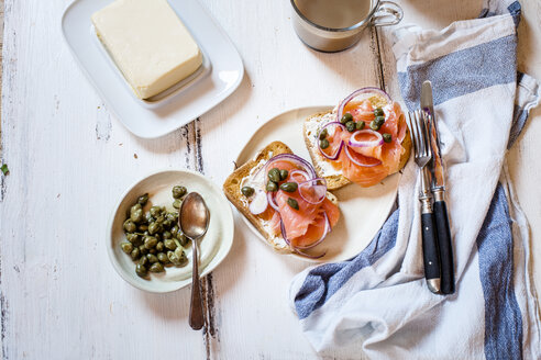 Toastbrotscheiben mit Räucherlachs, Kapernbeeren, Zwiebelringen und Kaffee - SBDF03821