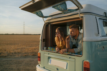 Couple brushing teeth in camper van in rural landscape - GUSF01417