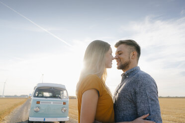 Affectionate young couple at camper van in rural landscape - GUSF01462