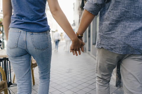 Niederlande, Maastricht, Nahaufnahme eines jungen Paares, das Hand in Hand durch die Stadt geht, lizenzfreies Stockfoto