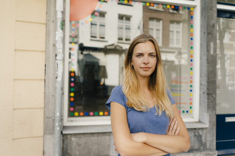 Niederlande, Maastricht, Porträt einer blonden jungen Frau in der Stadt, lizenzfreies Stockfoto