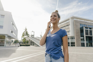 Netherlands, Maastricht, happy young woman on cell phone in the city - GUSF01531
